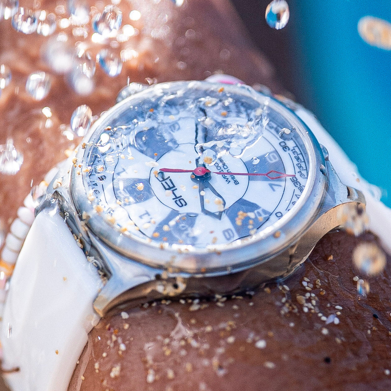 Watch with water droplets on a wrist, indicating water resistance.
